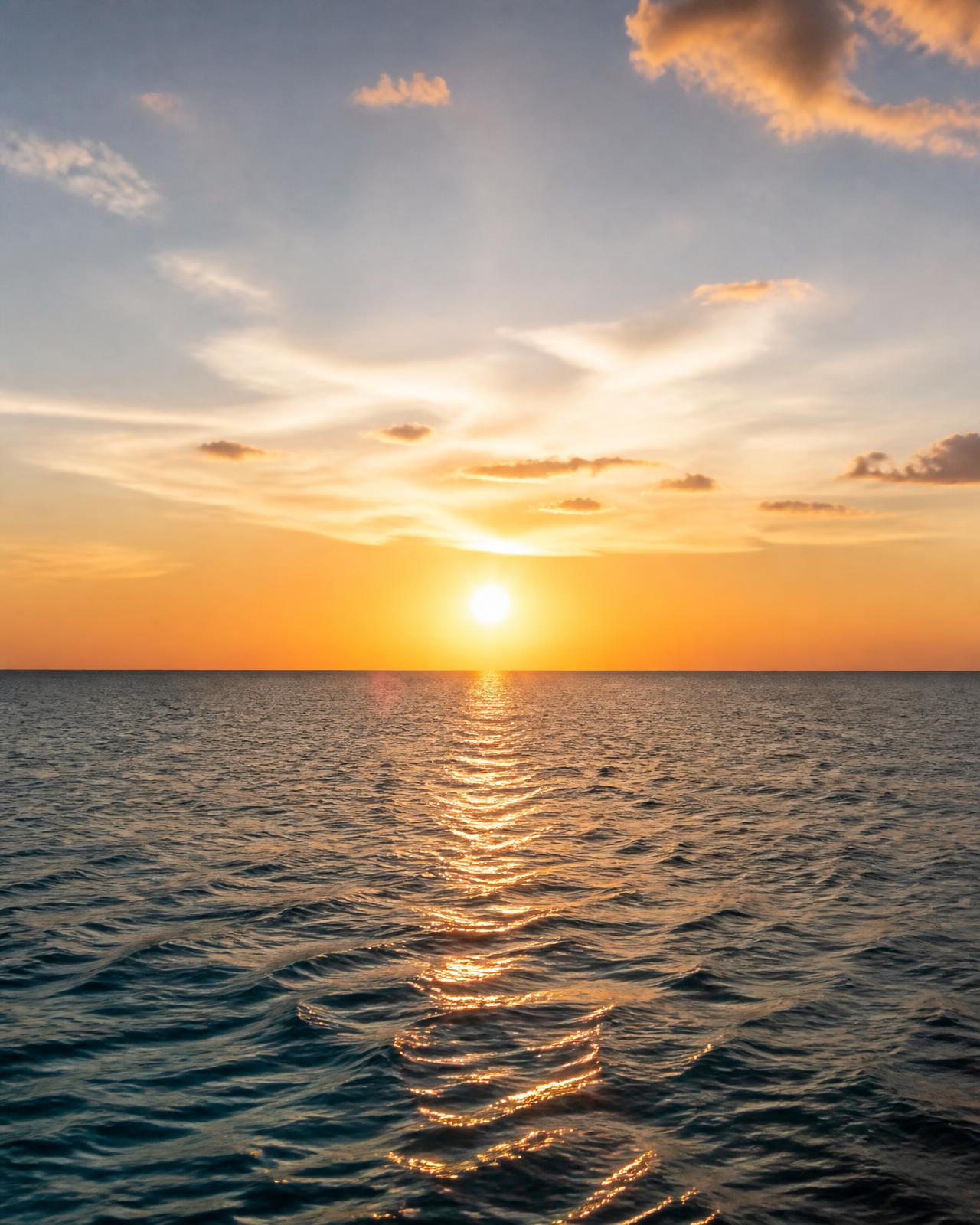 Golden sun over a calm open sea and bright sky — massage, wellness and health